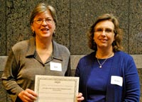 NCPC president KaeLi Schurr (r) presenting the award to Zoe Rhine (l), who accepted it on behalf of her colleagues Ann Wright, Betsy Murray, & Lyme Kedic.