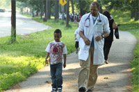 Photo of a doctor walking with a child.