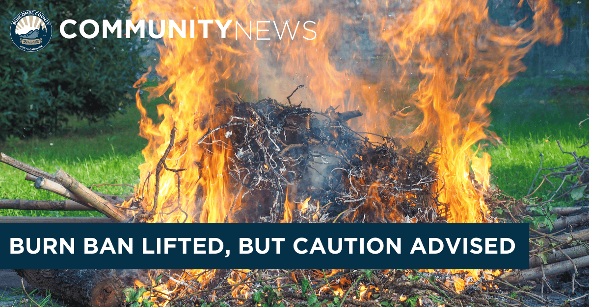 Vegetation burning in a small fire in a backyard with superimposed text saying community news and burn ban lifted but caution advised